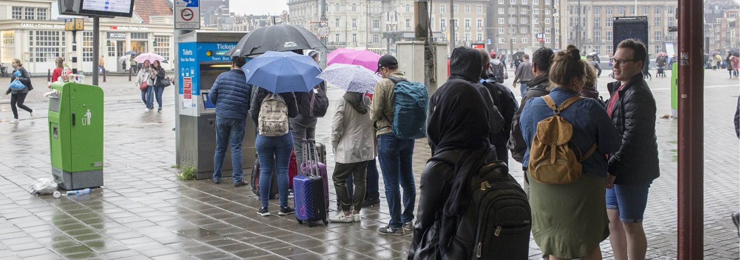 Toeristen in de rij voor GVB-kaartautomaat